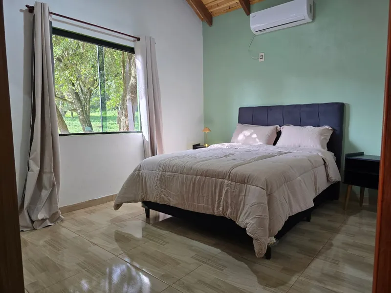 Habitacion con cama preparada y bandeja de desayuno sobre una mesa lateral
