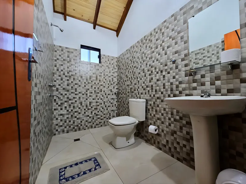 Baño minimalista con elementos de madera, velas aromáticas y toallas suaves en tonos naturales