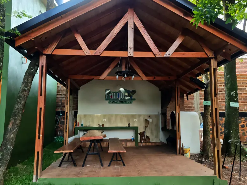 Fachada frontal del kincho con entrada iluminada, plantas y arquitectura acogedora